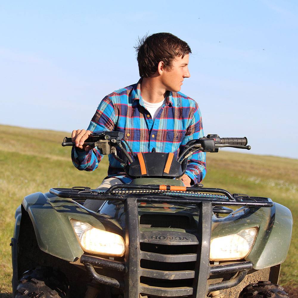 Caleb looks into the distance on his ATV.